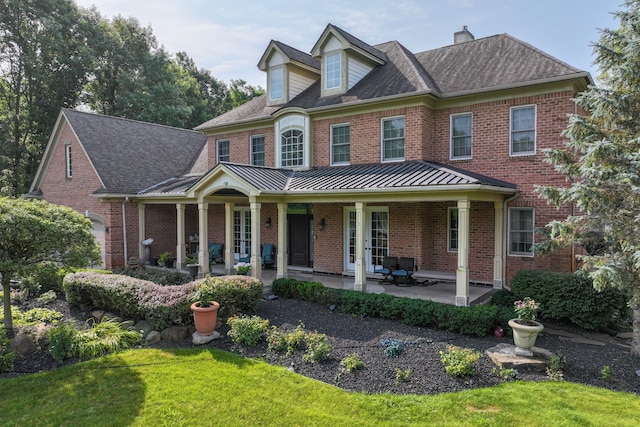 8557 Forestview Dr, Canton, MI 48187 - view of front facade with brick siding, a standing seam roof, a front yard, and metal roof