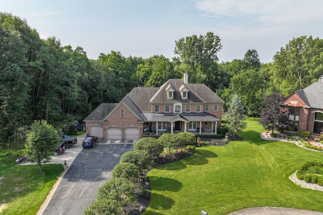 view of front of property featuring a garage, a porch, and a front yard