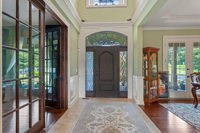 entrance foyer featuring french doors, plenty of natural light, crown molding, and hardwood / wood-style floors