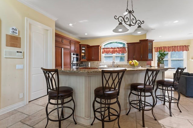 kitchen with tasteful backsplash, a wealth of natural light, dark stone countertops, and decorative light fixtures