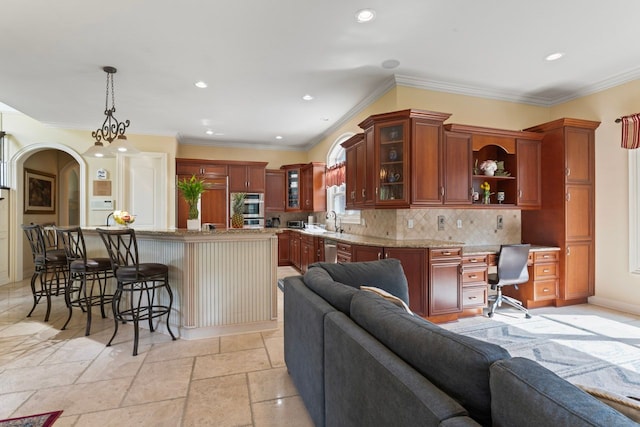 kitchen featuring sink, a breakfast bar area, tasteful backsplash, a kitchen island, and pendant lighting