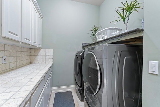 laundry area featuring washer and clothes dryer and cabinets