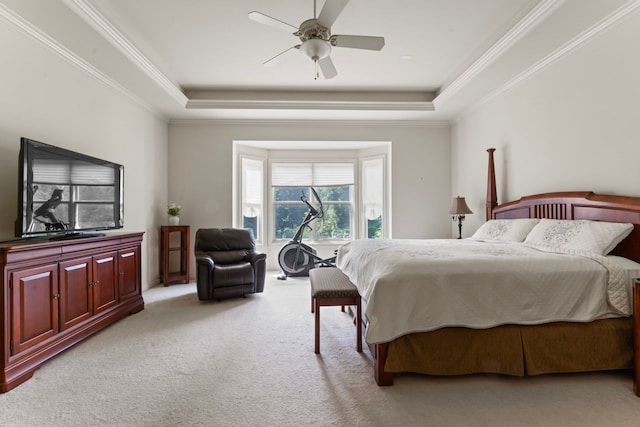 bedroom featuring ceiling fan, ornamental molding, a tray ceiling, and light colored carpet