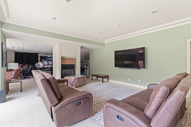 living room with a tile fireplace, ornamental molding, and light colored carpet