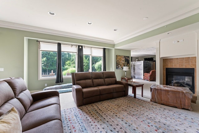 living room with light colored carpet, ornamental molding, and a tile fireplace