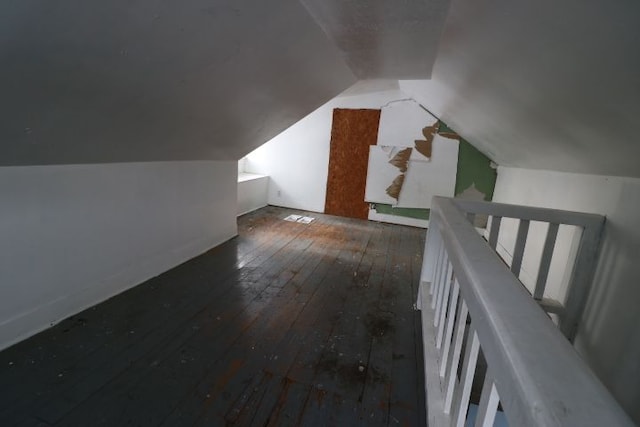 additional living space with vaulted ceiling and dark hardwood / wood-style floors