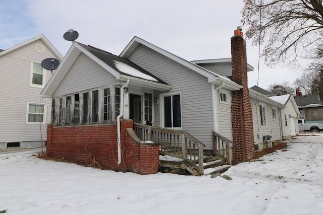 view of snow covered rear of property