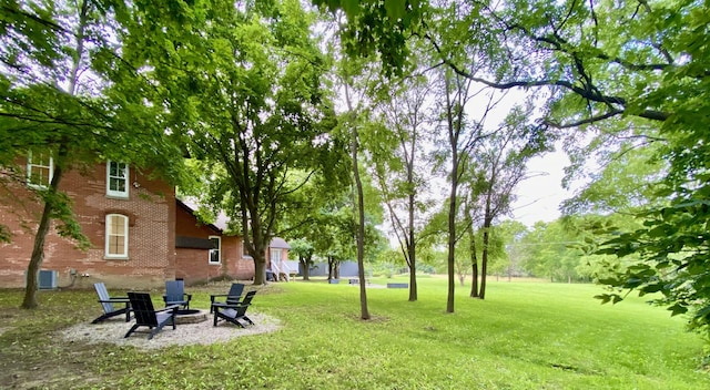 view of yard featuring cooling unit and a fire pit