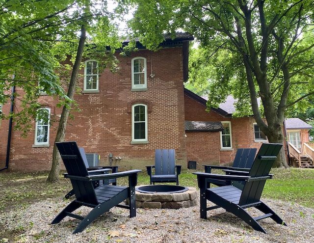 rear view of property featuring an outdoor fire pit