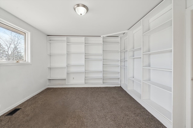 spacious closet featuring dark colored carpet