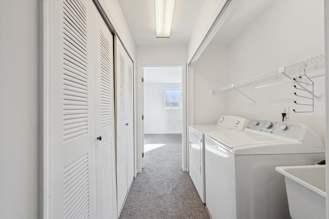 clothes washing area featuring sink, independent washer and dryer, and carpet