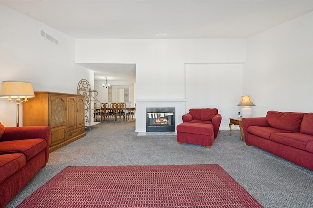 carpeted living room with a multi sided fireplace and a chandelier