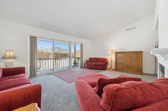 carpeted living room with a water view and vaulted ceiling