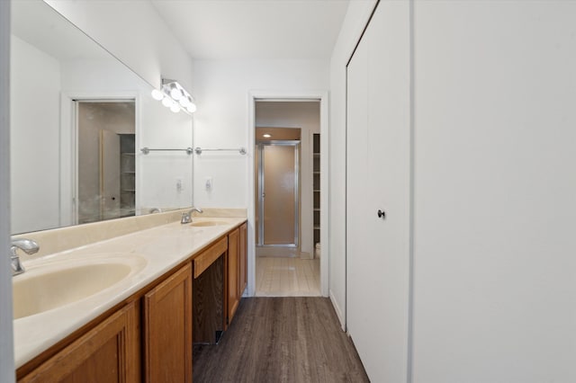 bathroom featuring walk in shower, wood-type flooring, and vanity