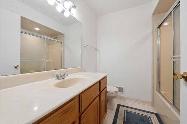 full bathroom with tile patterned flooring, vanity, bath / shower combo with glass door, and toilet