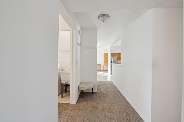 hallway featuring light colored carpet