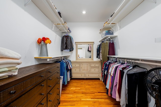 walk in closet with light hardwood / wood-style floors