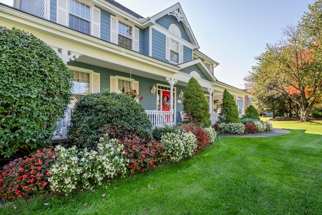 view of front facade with covered porch and a front lawn