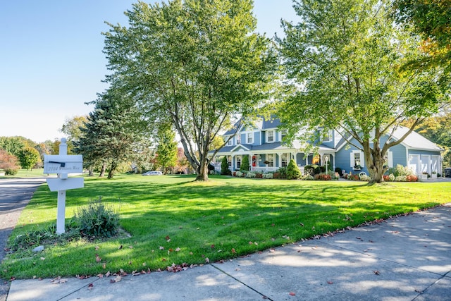 view of front of home with a garage, a front yard, and covered porch