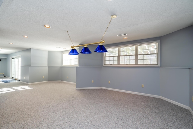 carpeted spare room with a textured ceiling