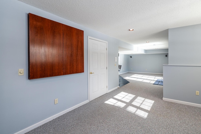 carpeted spare room featuring a textured ceiling