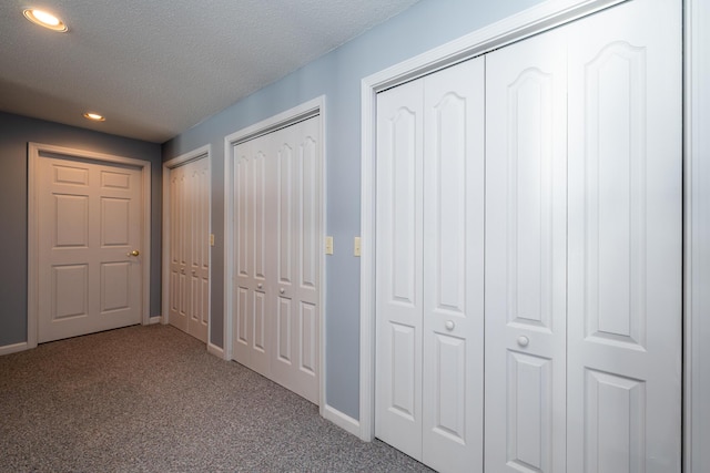 hallway with carpet floors and a textured ceiling