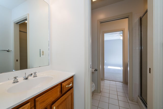 bathroom featuring tile patterned floors, toilet, an enclosed shower, and vanity