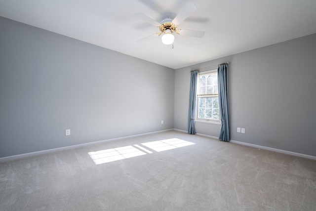 spare room featuring ceiling fan and light carpet