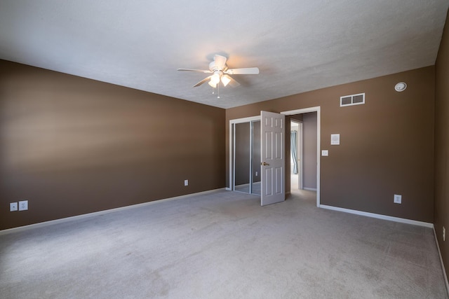 empty room with carpet floors, a textured ceiling, and ceiling fan