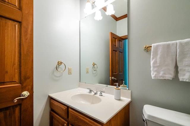 bathroom with vanity, ornamental molding, and toilet