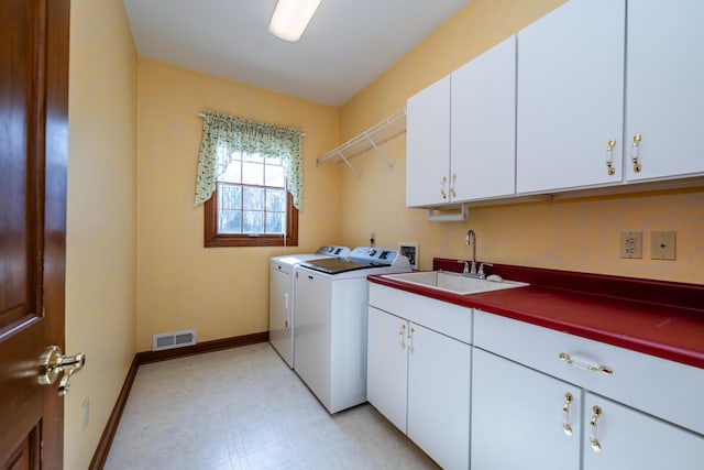 laundry area featuring sink, cabinets, and independent washer and dryer