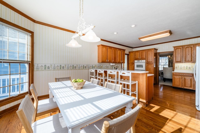 dining room with crown molding and light wood-type flooring