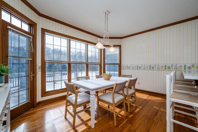 dining room featuring wood-type flooring, a notable chandelier, and crown molding