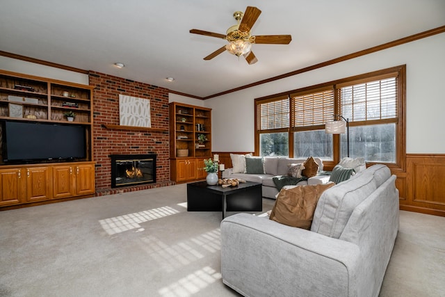 living room featuring ornamental molding, light colored carpet, ceiling fan, and a fireplace