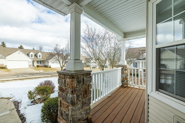 snow covered deck featuring a porch