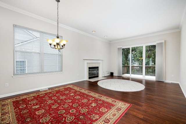 unfurnished living room with an inviting chandelier, dark wood-type flooring, a fireplace, and ornamental molding