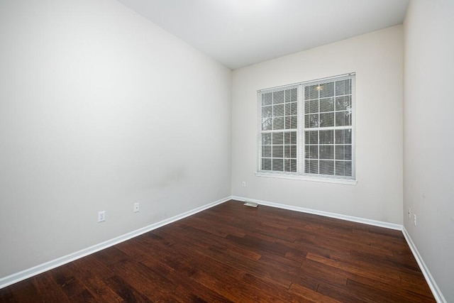 spare room with dark wood-type flooring