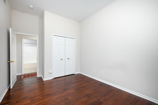 unfurnished bedroom featuring dark hardwood / wood-style floors and a closet