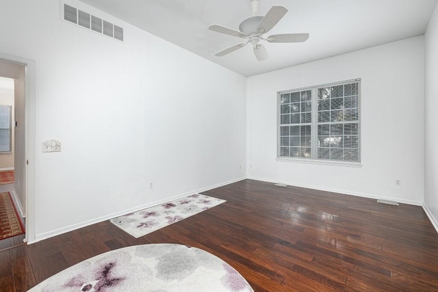 empty room with dark wood-type flooring and ceiling fan