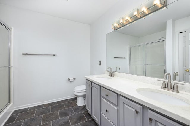 bathroom featuring vanity, toilet, and a shower with shower door