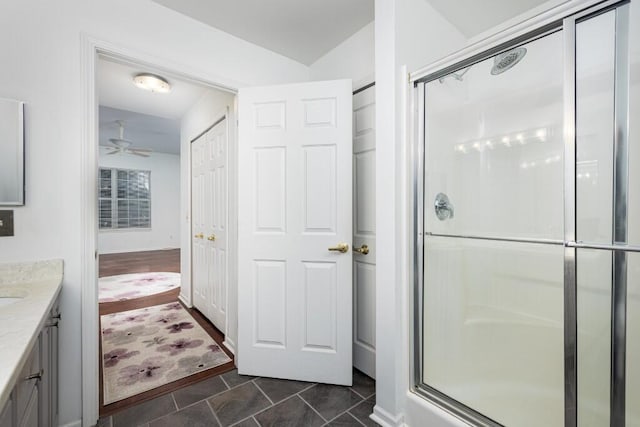 bathroom featuring walk in shower, ceiling fan, vanity, and tile patterned floors