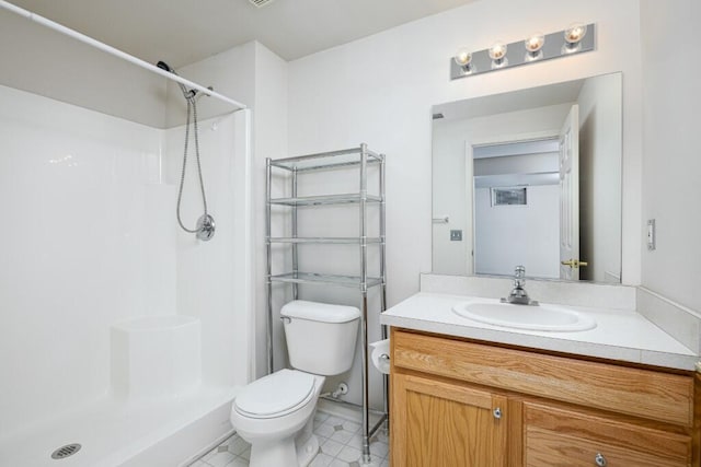 bathroom with vanity, toilet, and a shower