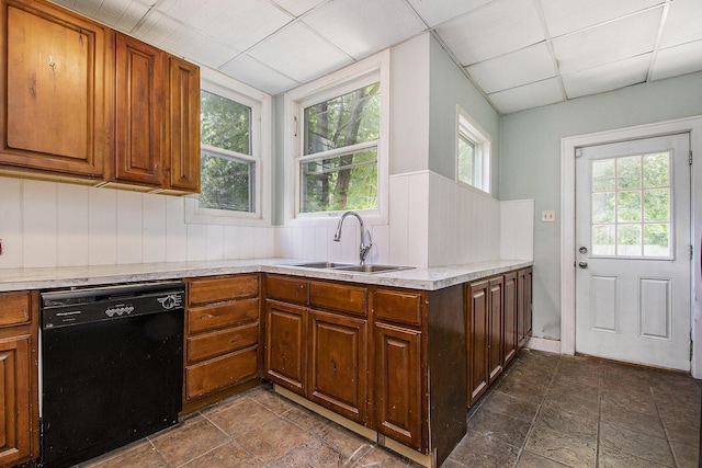 kitchen featuring black dishwasher, sink, and a drop ceiling