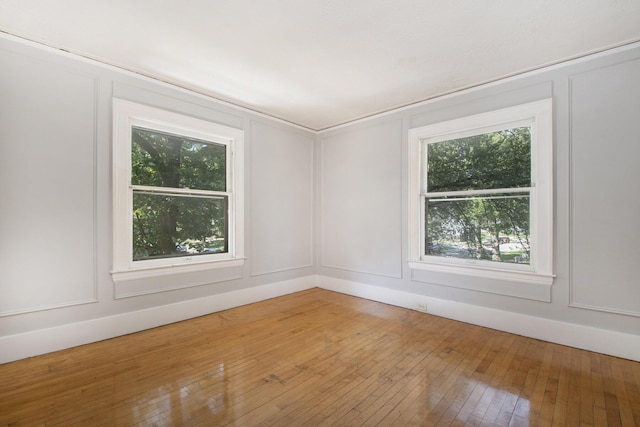 unfurnished room with hardwood / wood-style flooring and plenty of natural light