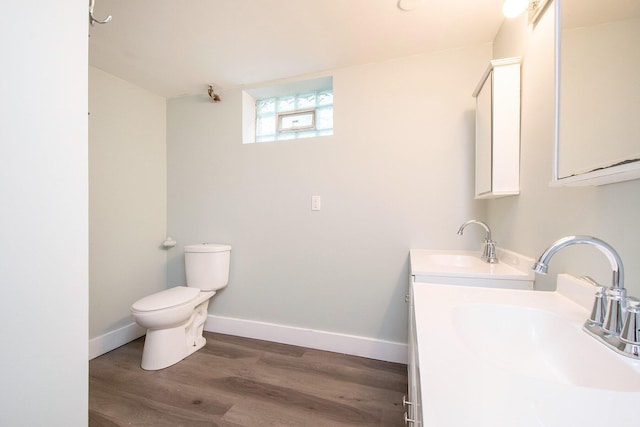 bathroom featuring wood-type flooring, toilet, and vanity