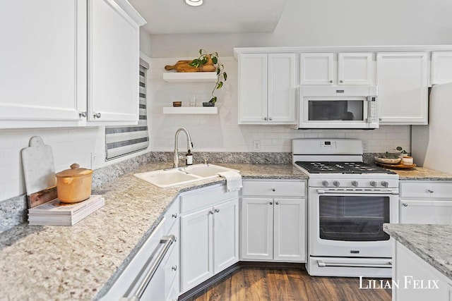 kitchen featuring white cabinetry, sink, backsplash, and white appliances