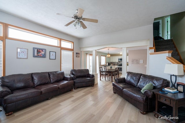 living room featuring decorative columns, ceiling fan, and light wood-type flooring