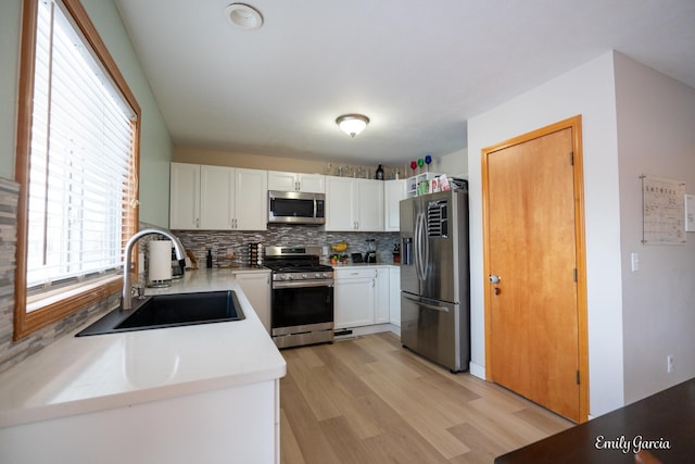 kitchen with white cabinetry, appliances with stainless steel finishes, sink, and decorative backsplash