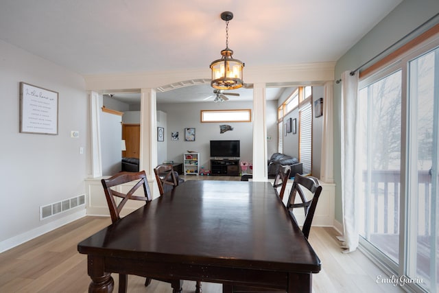 dining room featuring ornate columns and light hardwood / wood-style floors