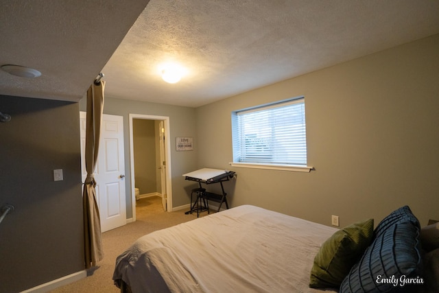 bedroom with light colored carpet and a textured ceiling